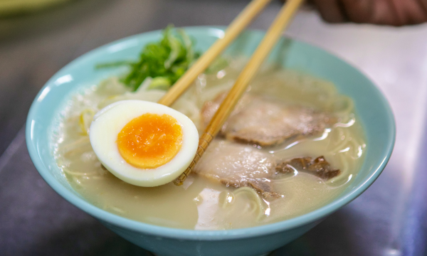 ラーメンに卵を乗せている様子