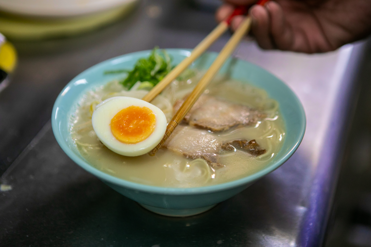 ラーメンに卵を乗せている様子